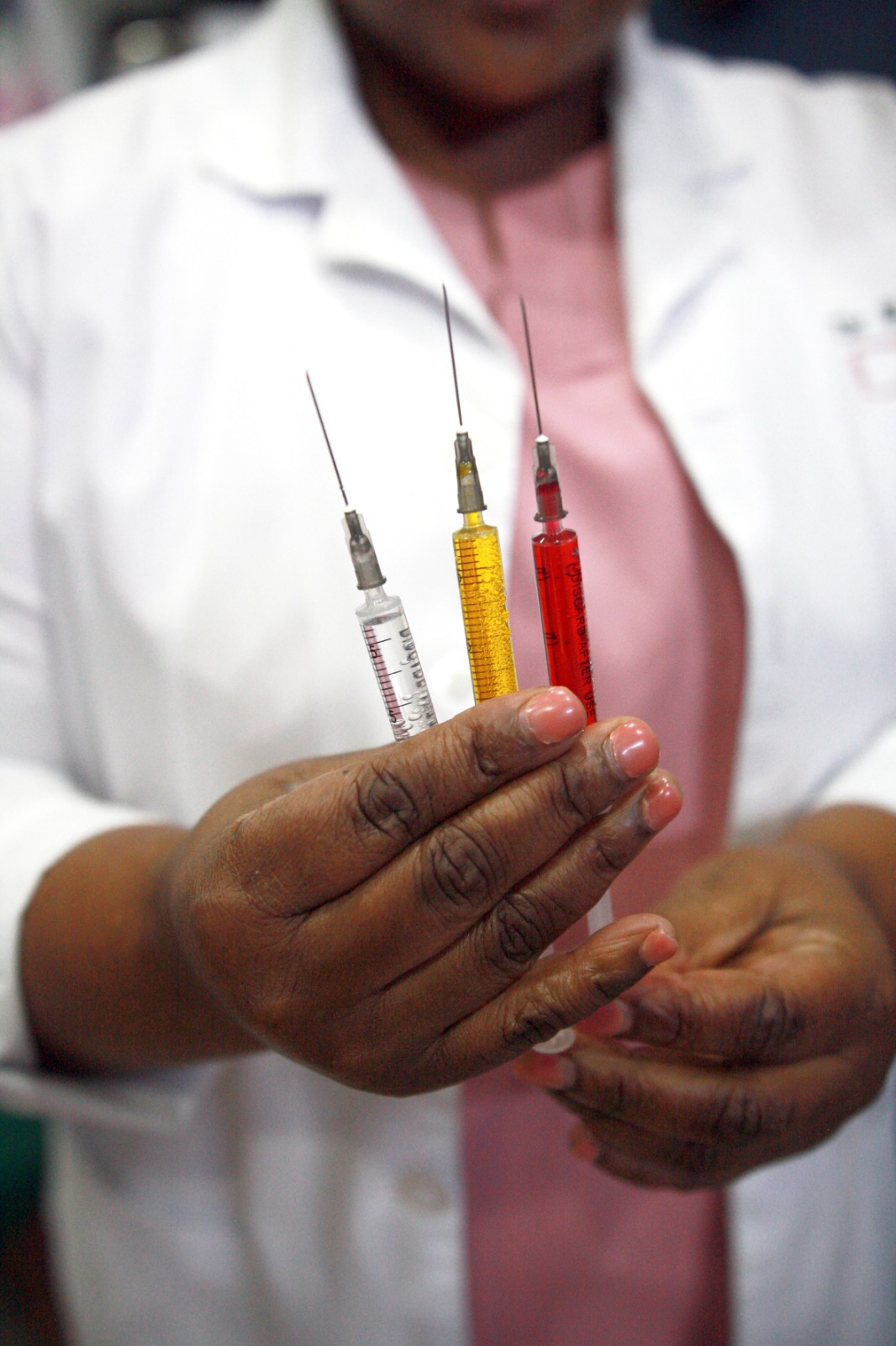 Dr Mxo holding prepared syringes